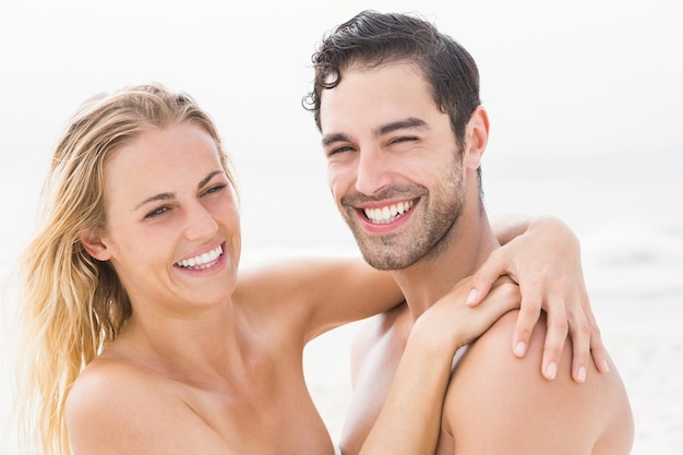 Coppie felici che abbracciano sulla spiaggia