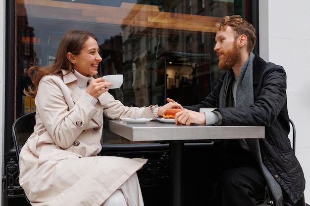 Coppie felici che bevono caffè e ridono parlando tra loro