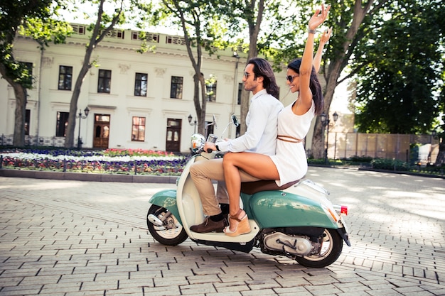 Coppie felici che guidano sullo scooter