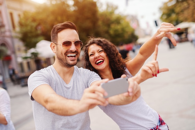 Coppie felici che prendono selfie sulla strada su estate. Concetto di viaggio.