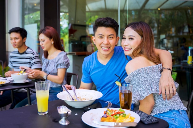 Coppie felici che sorridono alla macchina fotografica in caffè