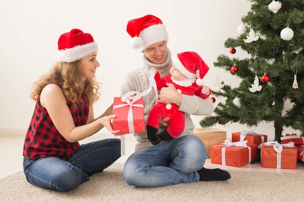 Coppie felici con il bambino che celebrano il Natale insieme a casa