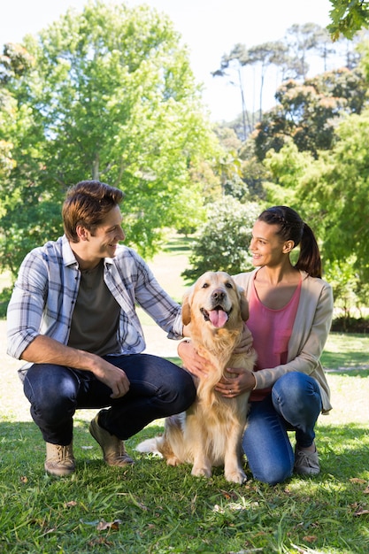 Coppie felici con il loro cane nel parco