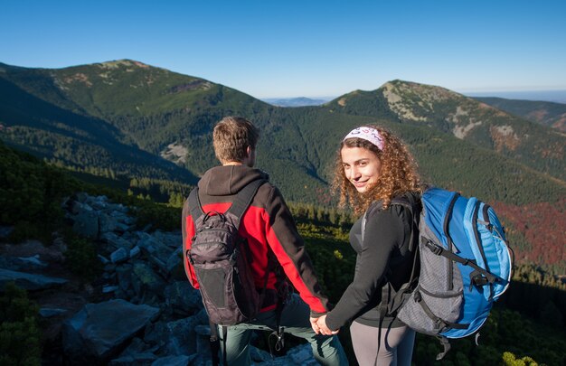 Coppie felici della viandante che camminano in natura su nelle montagne