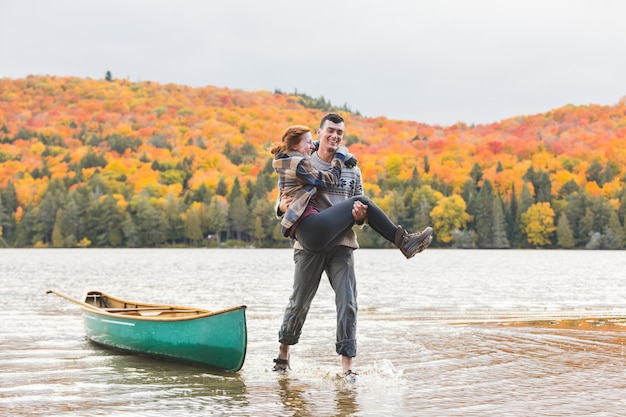 Coppie felici dopo il viaggio della canoa nel lago nel Canada