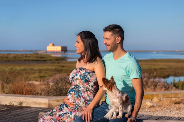 Coppie felici incinte con il piccolo cane