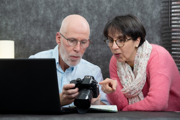 Coppie maggiori che guardano le immagini di vacanza sulla macchina fotografica