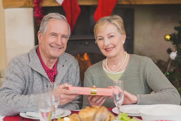 Coppie maggiori che tengono un regalo di Natale