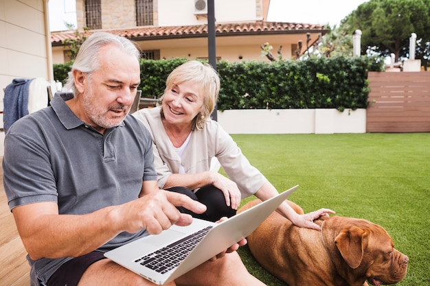 Coppie maggiori con il cane in giardino