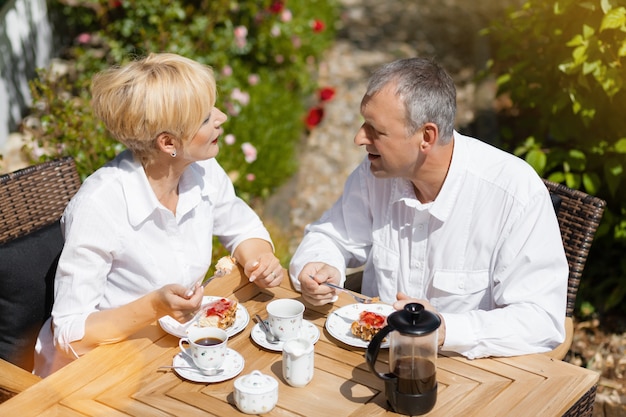 Coppie maggiori in giardino con caffè