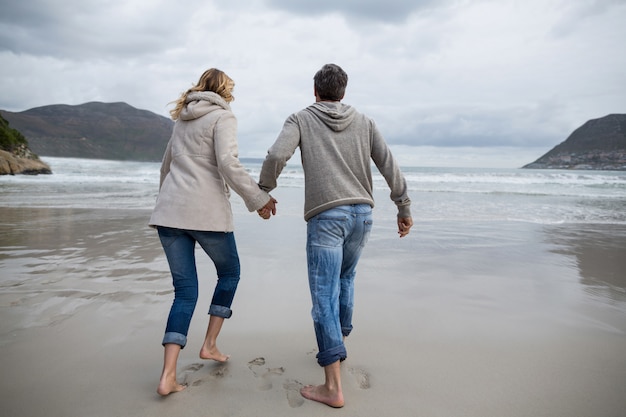 Coppie mature che funzionano sulla spiaggia