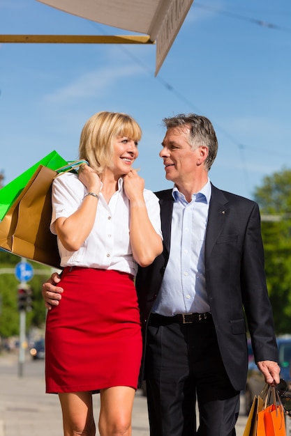 Coppie mature che passeggiano attraverso lo shopping della città in primavera