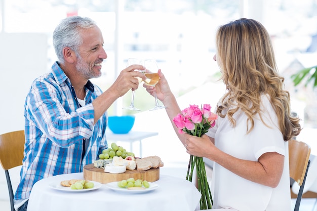 Coppie mature che tostano bicchiere di vino in ristorante