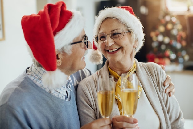 Coppie mature gioiose che brindano con Champagne mentre festeggiano il nuovo anno a casa