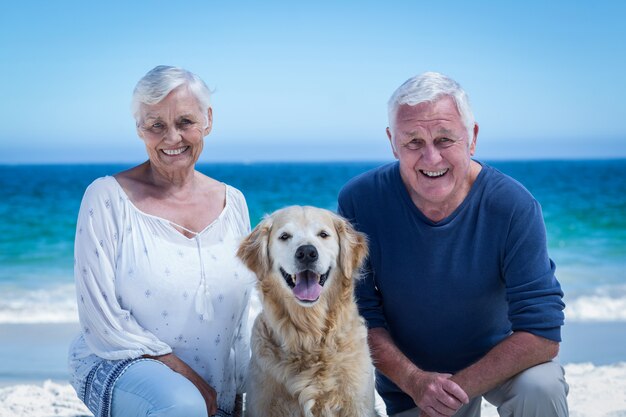 Coppie mature sveglie che posano con il loro cane