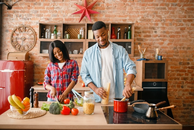 Coppie nere di amore che cucinano la cena romantica