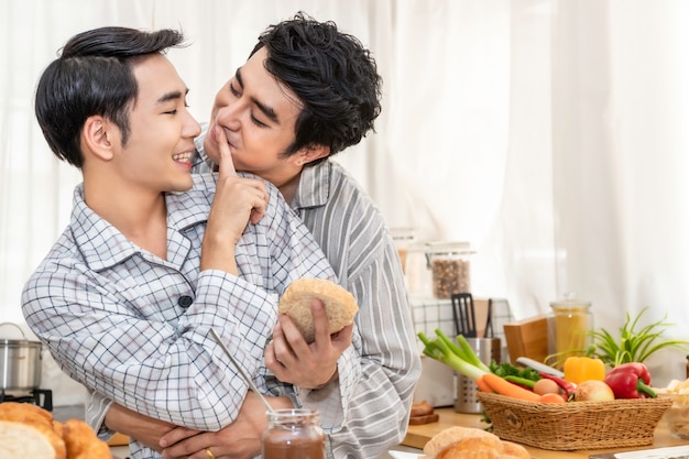 Coppie omosessuali asiatiche che cucinano prima colazione alla cucina nel morinking. Concetto LGBT gay.