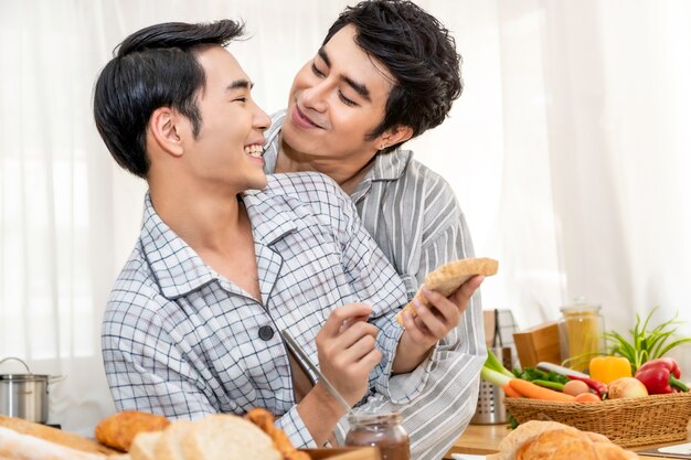 Coppie omosessuali asiatiche che cucinano prima colazione alla cucina nel morinking