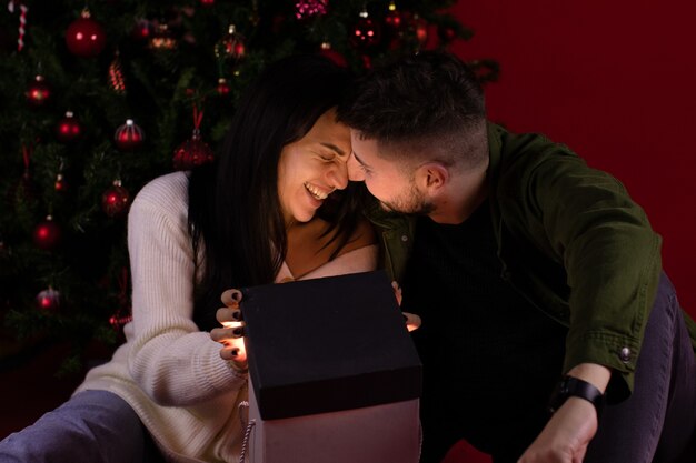 Coppie romantiche che aprono il regalo di Natale magico