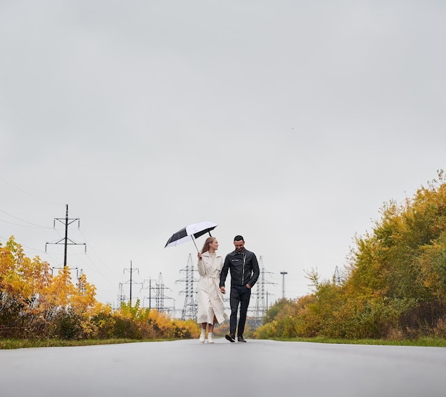 Coppie romantiche che camminano sulla strada nel giorno di autunno