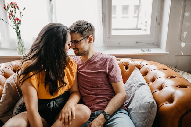 Coppie romantiche che si siedono sul sofà a casa