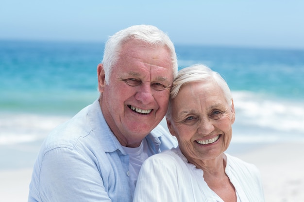 Coppie senior che abbracciano alla spiaggia