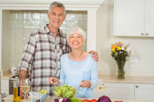 Coppie senior che preparano insalata di verdure