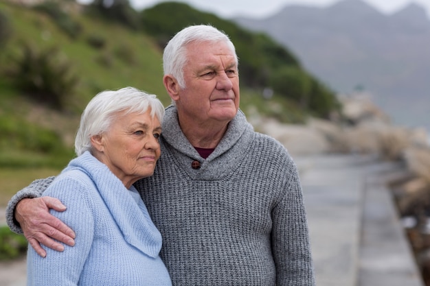 Coppie senior che si abbracciano sulla spiaggia