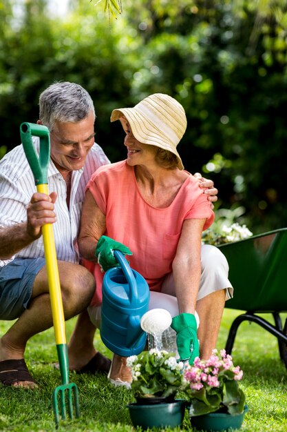 Coppie senior con attrezzatura per il giardinaggio all'iarda