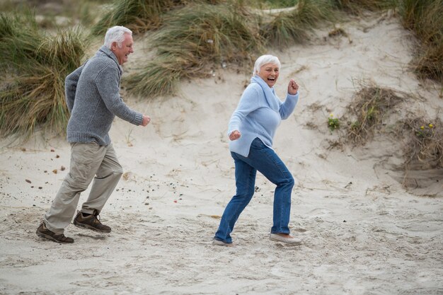 Coppie senior divertendosi insieme alla spiaggia