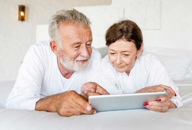 Coppie senior facendo uso di una compressa a letto