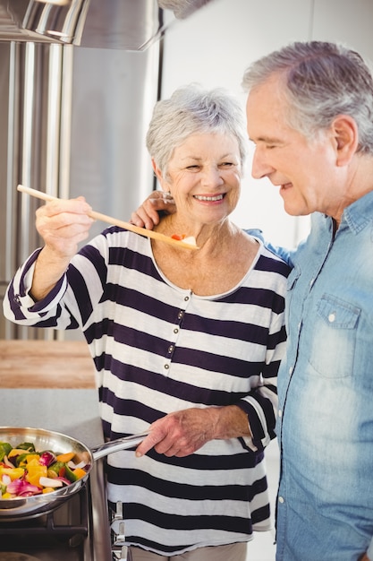 coppie senior felici che cucinano alimento