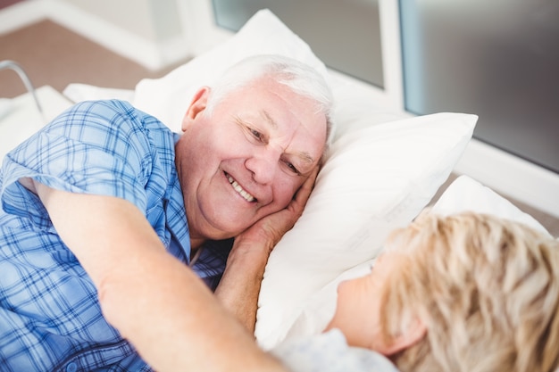 Coppie senior felici che si trovano sul letto