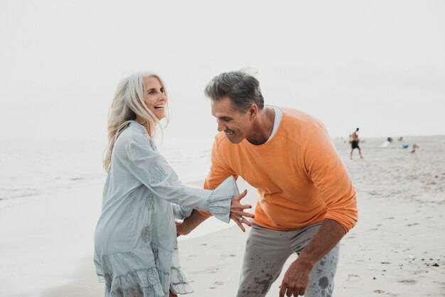 Coppie senior felici che spendono tempo alla spiaggia. Concetti su amore, anzianità e persone