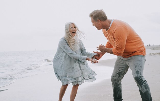 Coppie senior felici che spendono tempo alla spiaggia. Concetti su amore, anzianità e persone