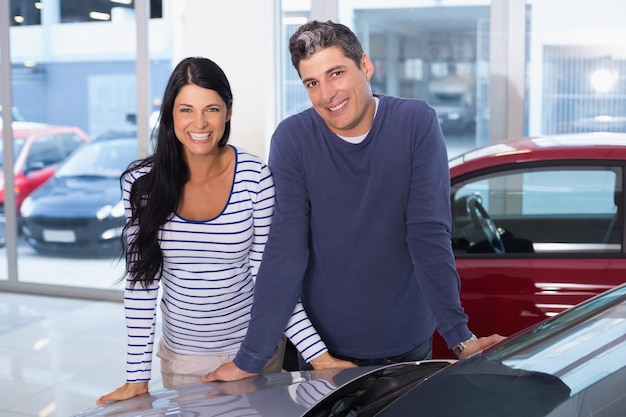 Coppie sorridenti che si appoggiano automobile