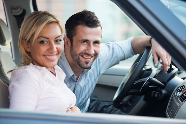 Coppie sorridenti che si siedono in un&#39;automobile