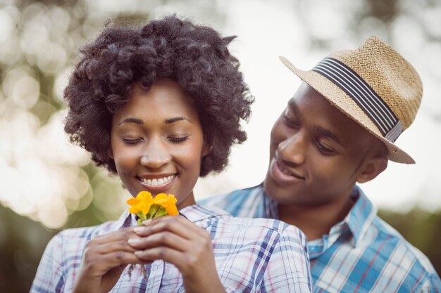 Coppie sorridenti che tengono i fiori gialli nel giardino