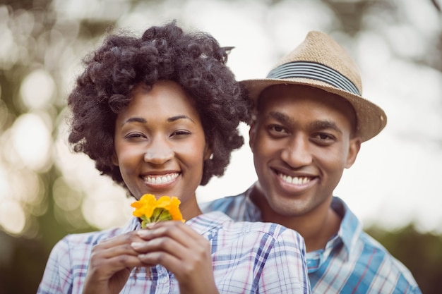 Coppie sorridenti che tengono i fiori gialli nel giardino