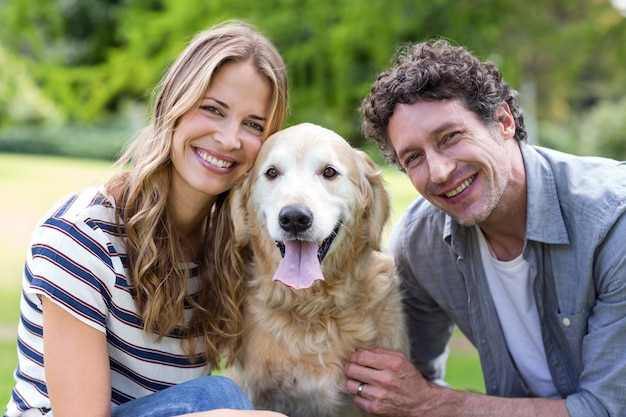 Coppie sorridenti con il cane nel parco