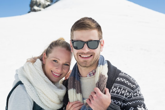 Coppie sorridenti davanti alla collina nevicata