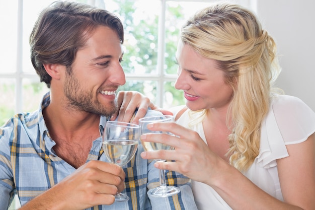 Coppie sorridenti sveglie che godono insieme del vino bianco