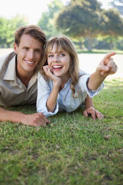 Coppie spensierate che si trovano nel parco con indicare della donna