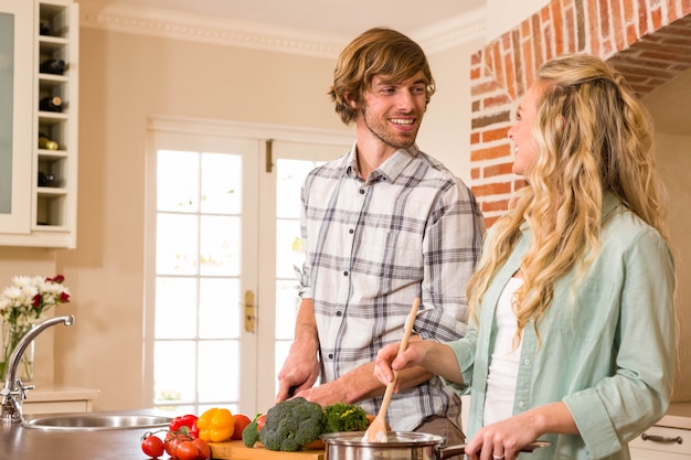 Coppie sveglie che cucinano insieme nella cucina