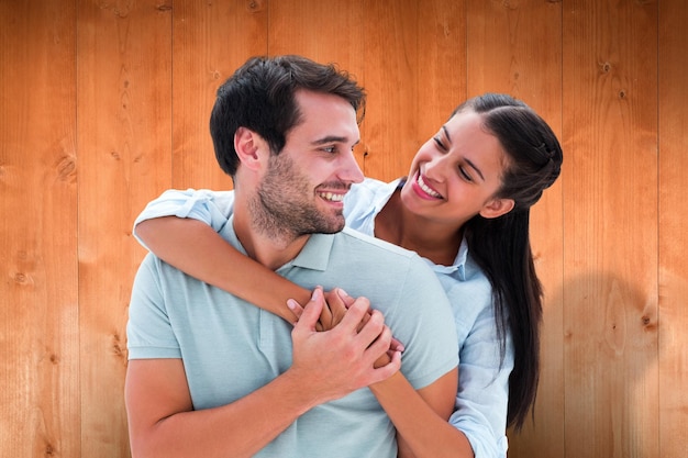 Coppie sveglie che si sorridono contro le plance di legno