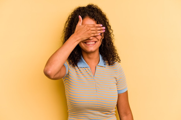 Copre gli occhi con le mani sorride ampiamente in attesa di una sorpresa