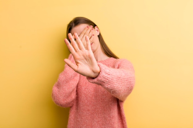 coprendo il viso con la mano e mettendo l'altra mano in avanti per impedire alla fotocamera di rifiutare foto o immagini