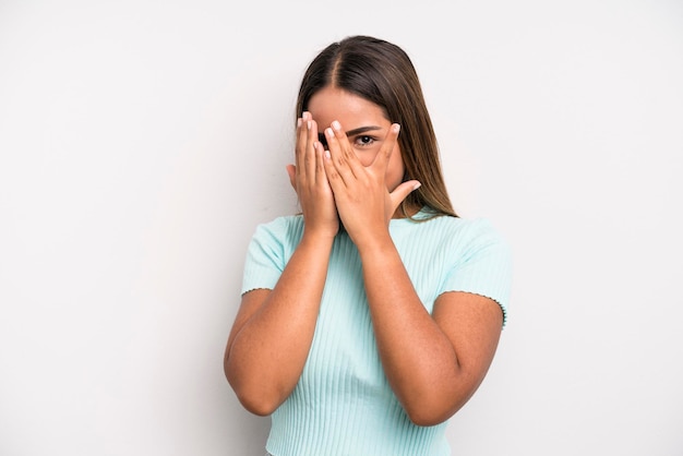 Coprendo il viso con le mani che sbirciano tra le dita con espressione sorpresa e guardano di lato