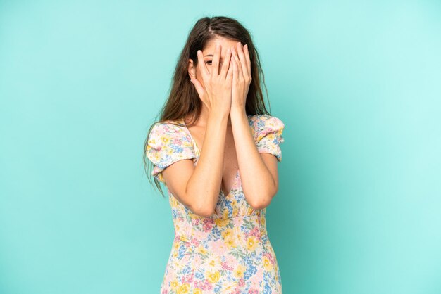Coprendo il viso con le mani che sbirciano tra le dita con espressione sorpresa e guardano di lato