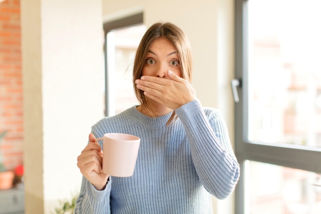 coprendosi la bocca con le mani con un'espressione scioccata e sorpresa, mantenendo un segreto o dicendo oops